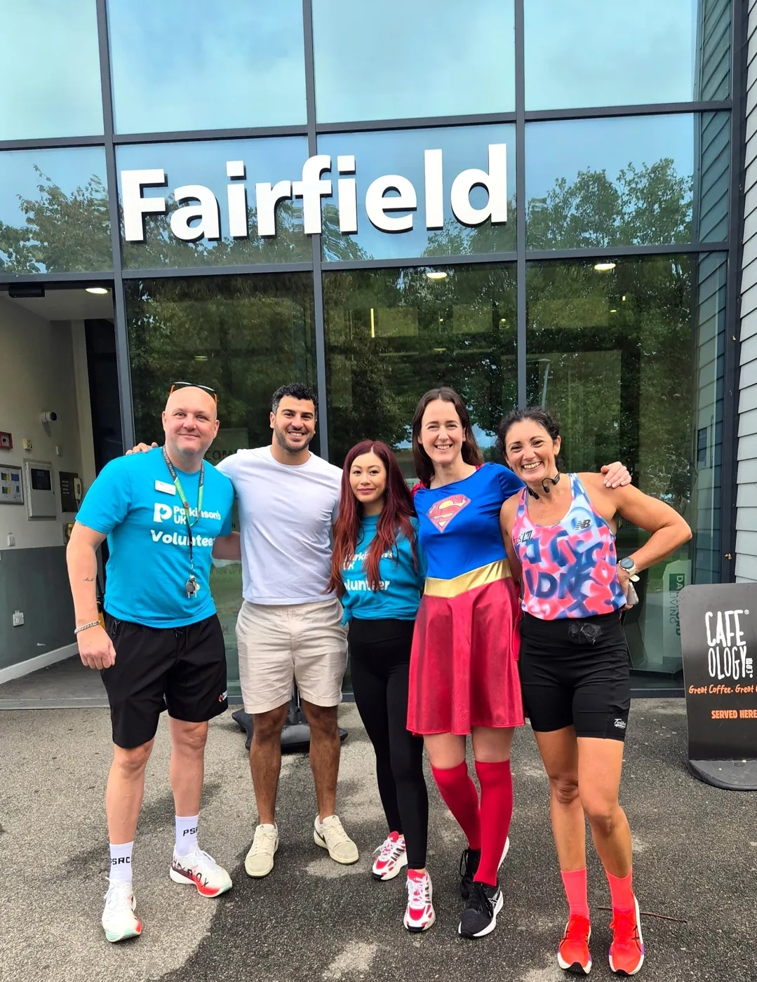 Five Spinathon supporters, two in Parkinson's UK volunteer T-shirts, outside the Fairfield building